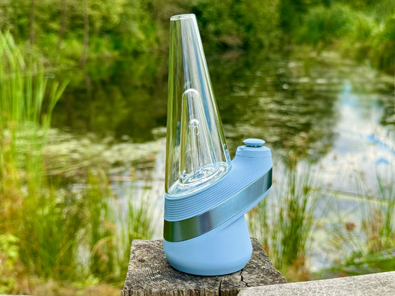 new puffco peak in sky blue on wooden post with pond in background