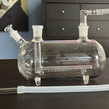 XL Super Sub Pipe Side View – A clear glass, horizontally oriented water pipe with a sleek design and stable four-footed base.