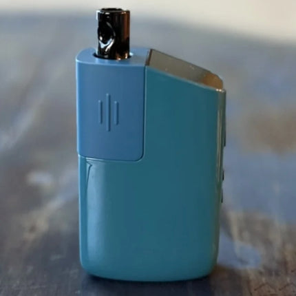Teal Fury 3 dry herb vaporizer standing upright on a wood surface, showcasing its compact and stylish design.