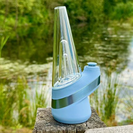 new puffco peak in sky blue on wooden post with pond in background