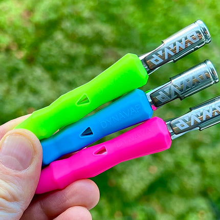 Holding green, blue and pink Dynavap B Portable Vaporizer.