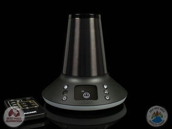 Arizer XQ2 desktop vaporizer on black background with remote control next to it.