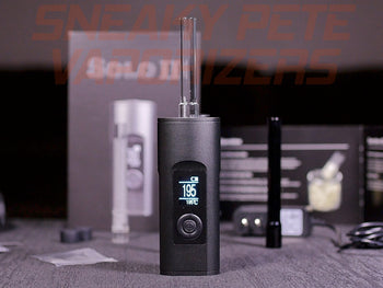 Black Arizer Solo 2 portable dry herb vaporizer with accessories standing on a table. 