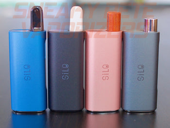 Black, blue, grey, and pink CCell Silo, with cartridges inserted, standing next to each other on a table.