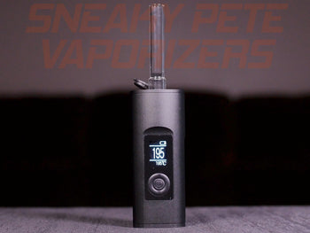 Black Arizer Solo 2 portable dry herb vaporizer with a stem inserted, standing on a table.  