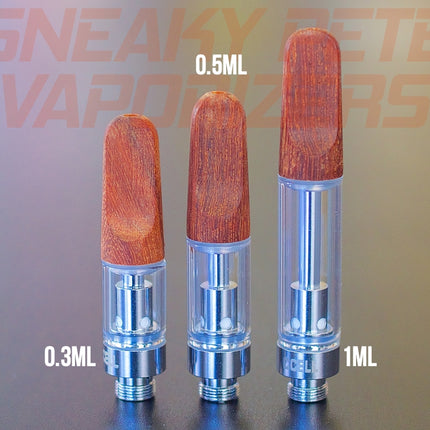 1ml, 0.5ml and 0.3ml wooden CCell TH2 oil cartridges standing next to each other on a table.