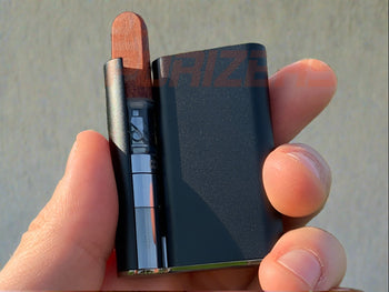 Holding black Ccell Palm with cartridge inserted outside.