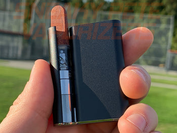 Holding black Ccell Palm with cartridge inserted outside.