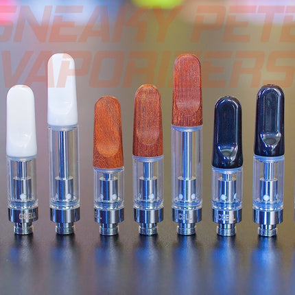 1ml, 0.5ml and 0.3ml white, wooden and black CCell TH2 oil cartridges standing on a table.