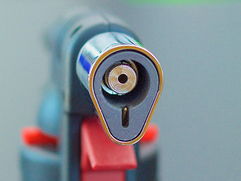 Closeup of a glass nozzle of Blazer Firefox Butane Torch lighter.