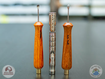 2 Ed's TNT Pack & Stir Tools on a table with Dynavap M in between them.