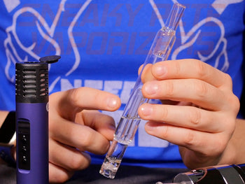 Sneaky Pete holding Arizer Bubble Straw filled with water. Arizer Air 2 is standing next to it.